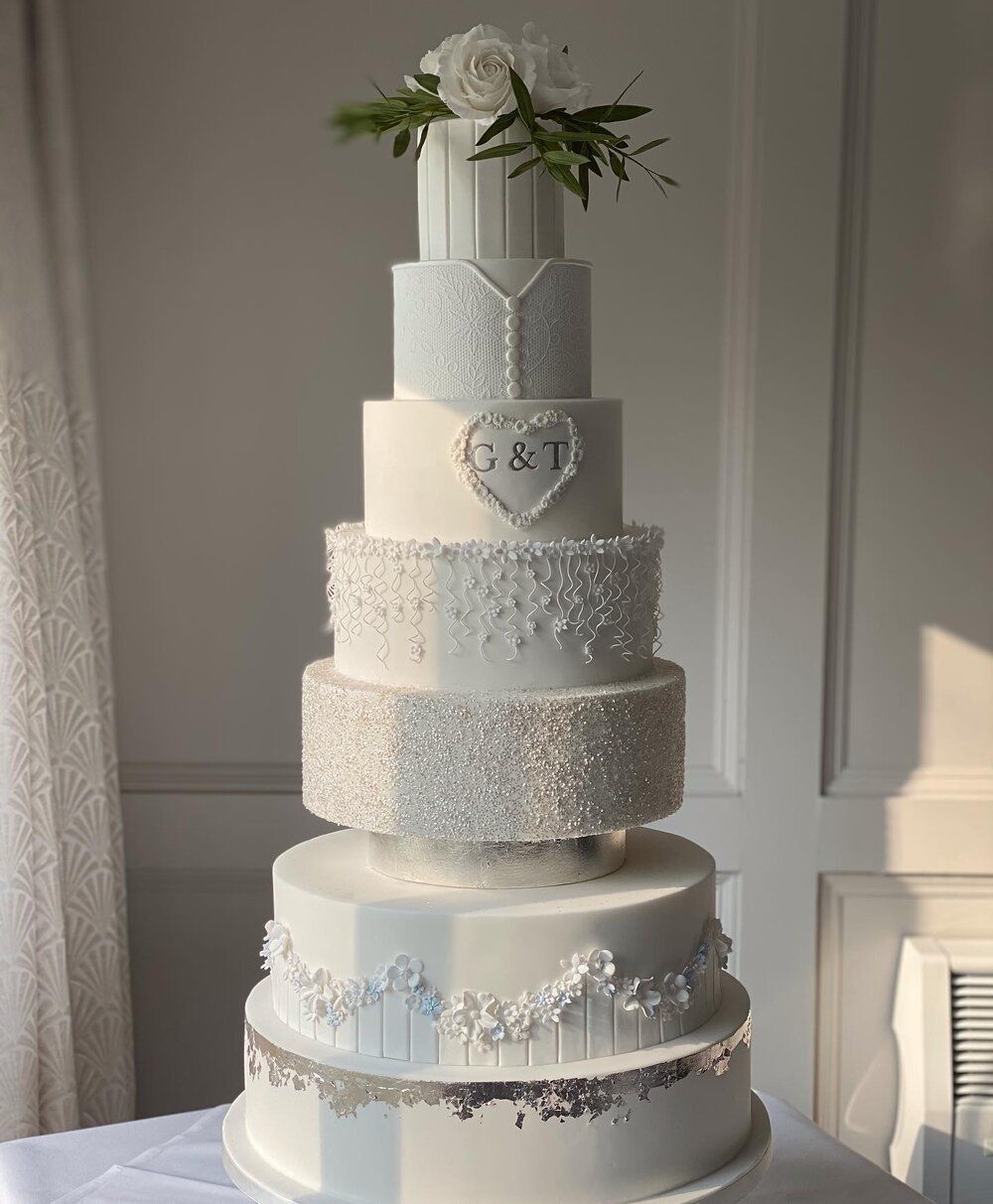A very tall wedding cake is sitting on top of a table.