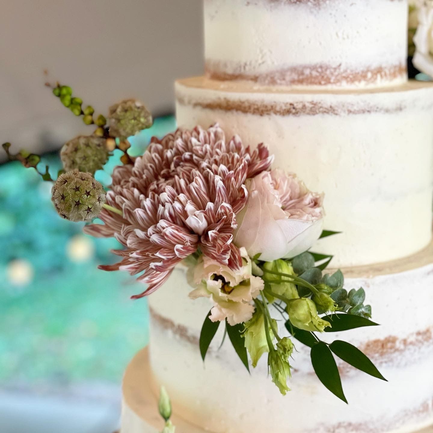 A close up of a wedding cake with flowers on it