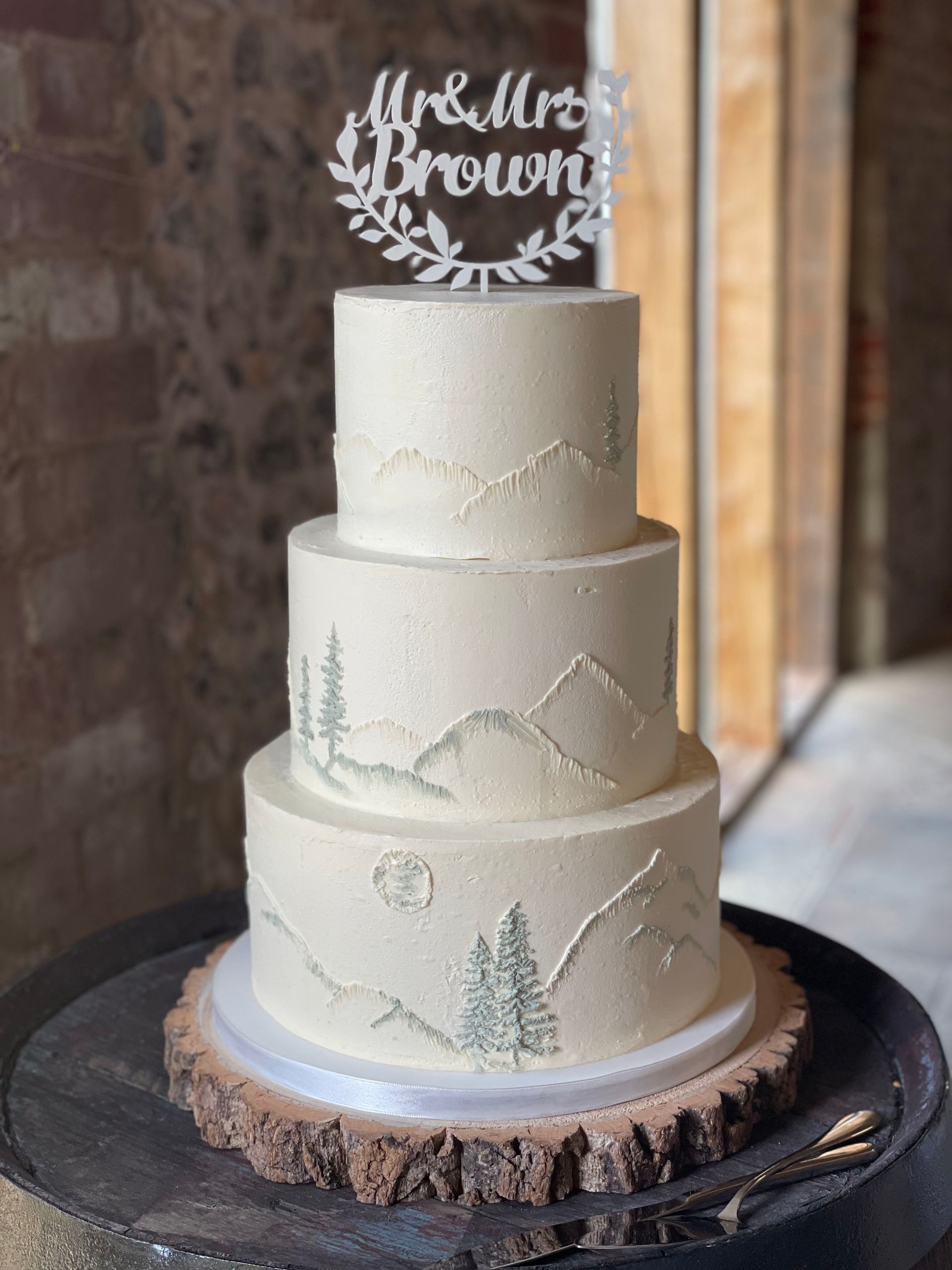 A wedding cake is sitting on top of a wooden table.