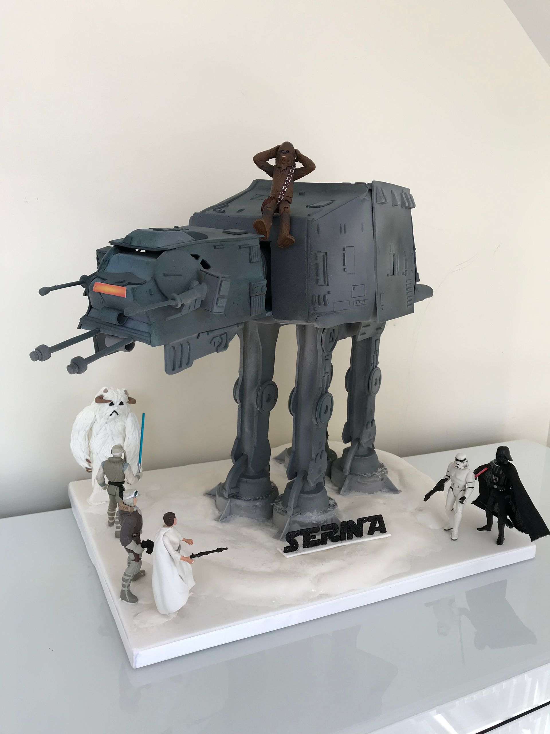 A star wars cake with at at walkers and stormtroopers on it.