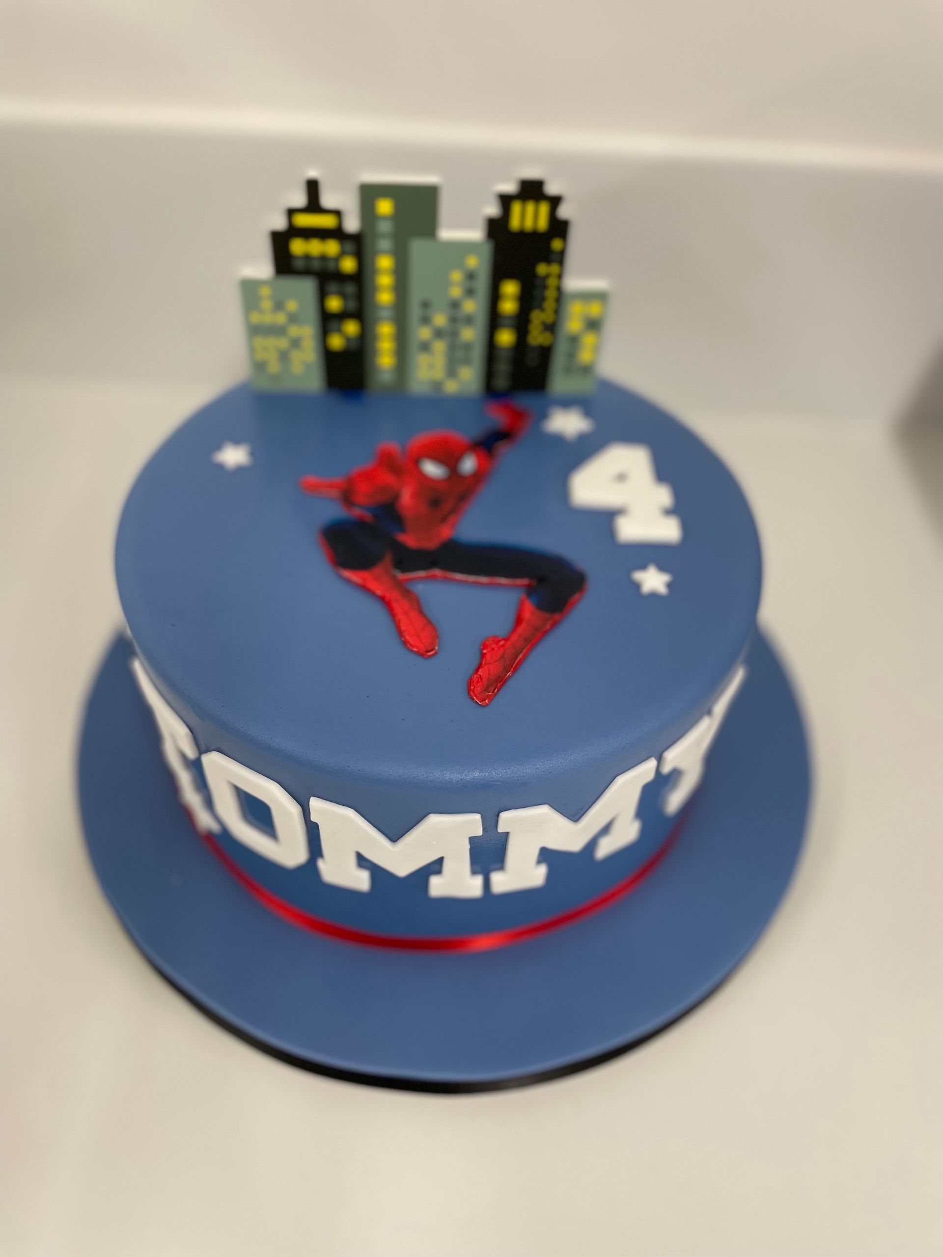 A blue cake with the name tommy on it