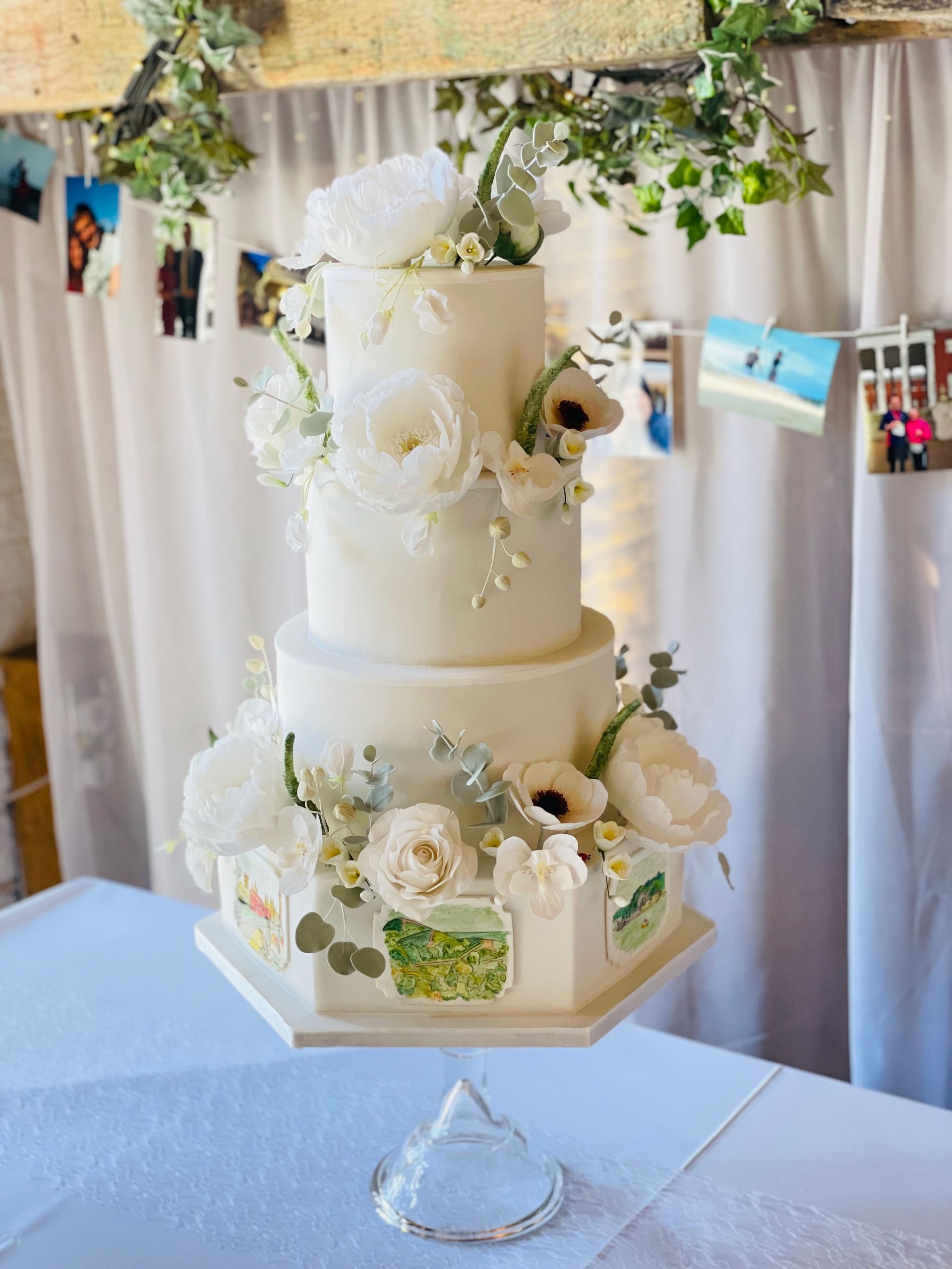 A white wedding cake with white flowers is sitting on a table.