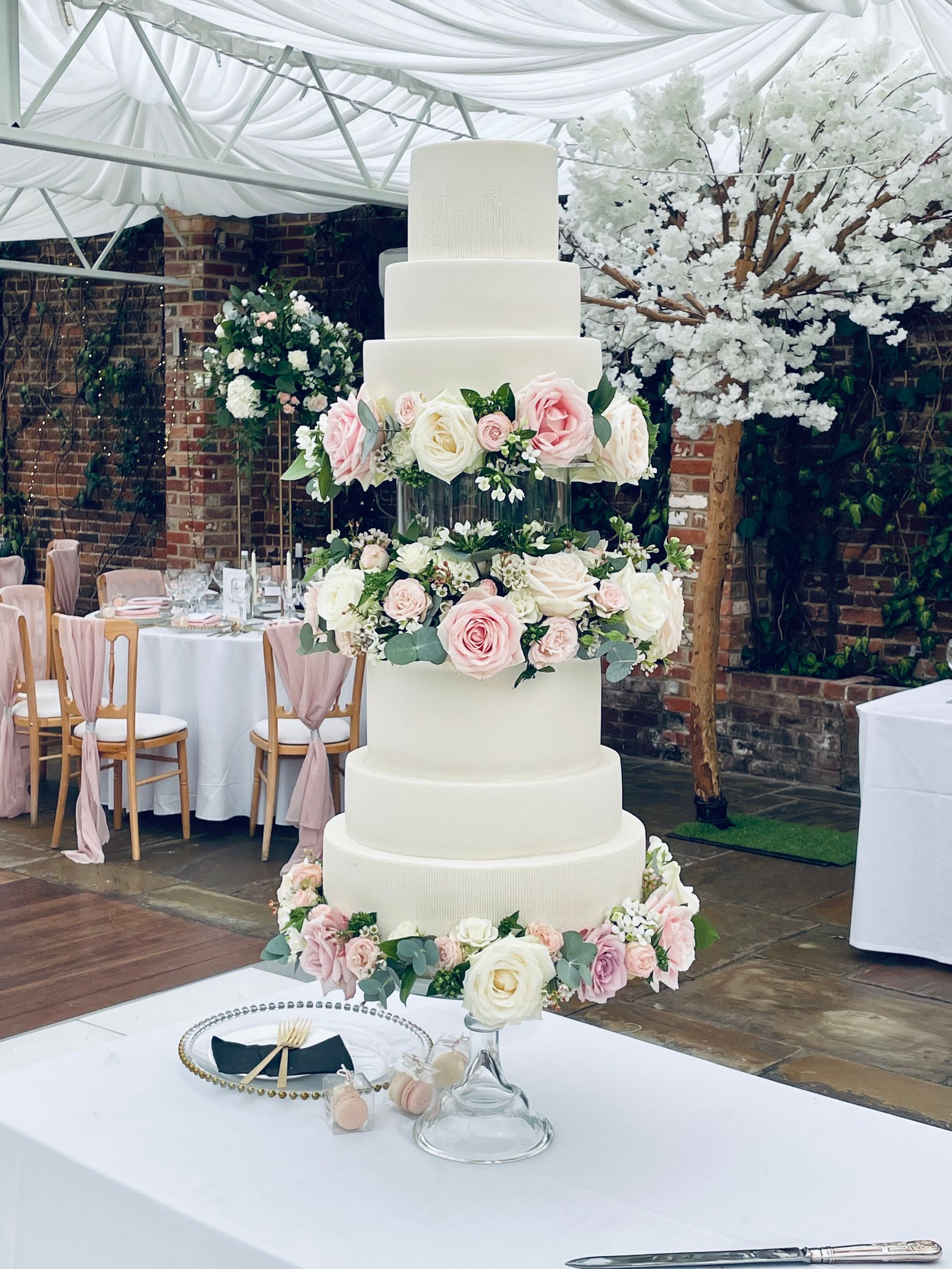A wedding cake is sitting on top of a table decorated with flowers.