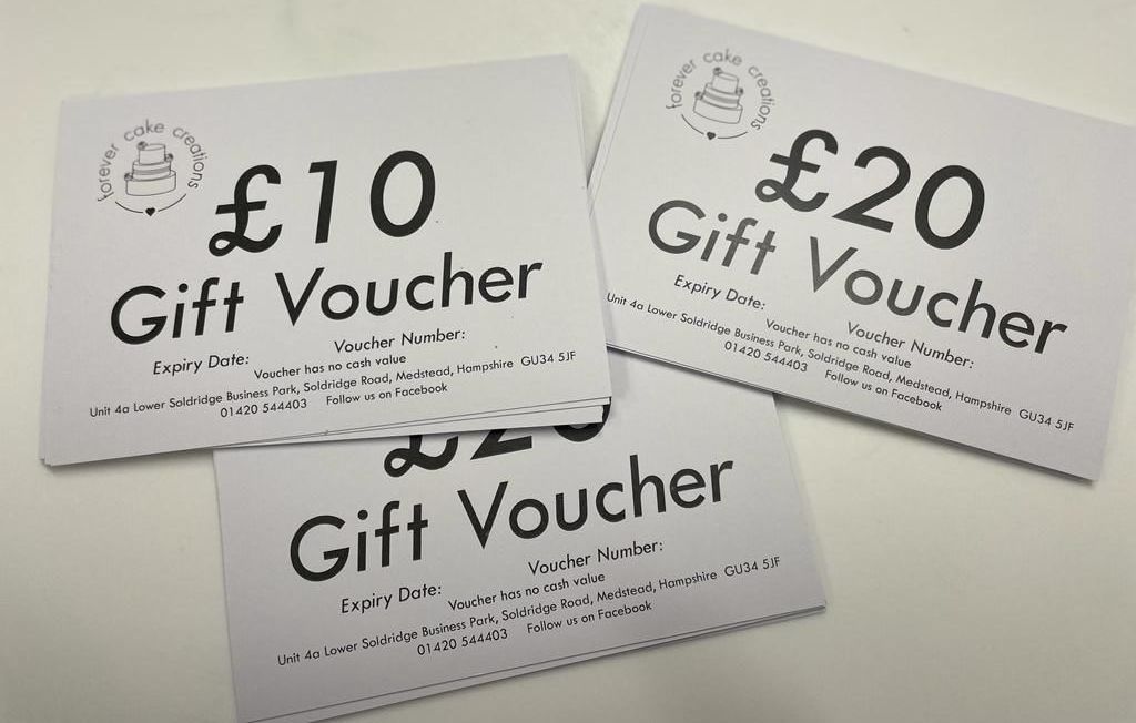 Three gift vouchers are stacked on top of each other on a table.