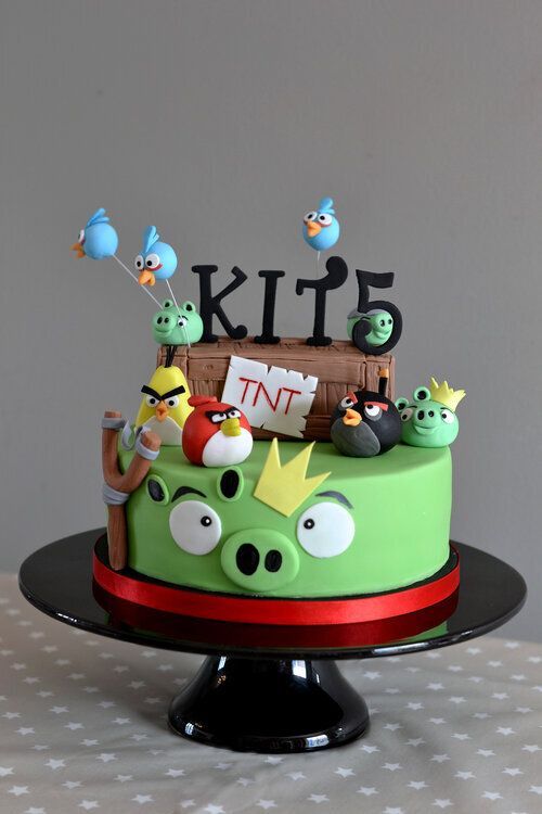 A cake with angry birds and the name kits on top