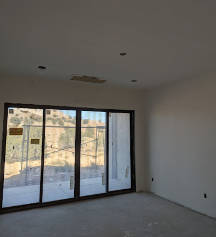 An empty room with a lot of windows and a mountain in the background