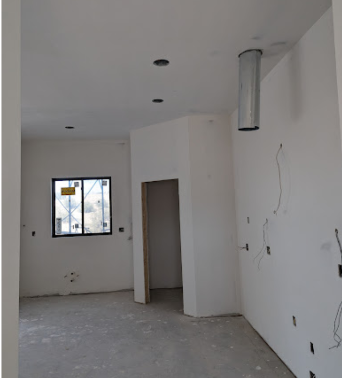 An empty room with white walls and a window