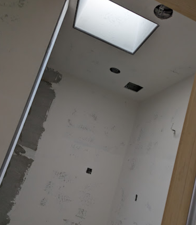 A white room with a square light on the ceiling