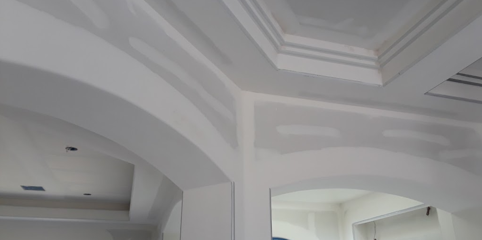A room with white walls and a ceiling that is being remodeled.