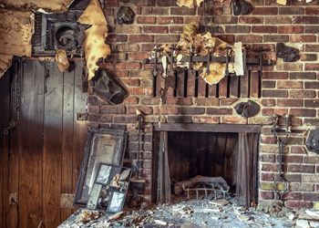 There is a fireplace in the middle of a room with a brick wall.