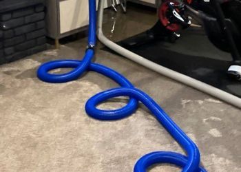 A blue hose is sitting on the floor in a room.
