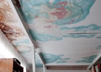 Damaged ceiling with water stains; blue, pink, and brown discoloration.
