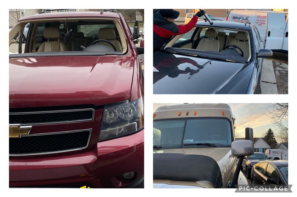 A man is cleaning the windshield of a red suv
