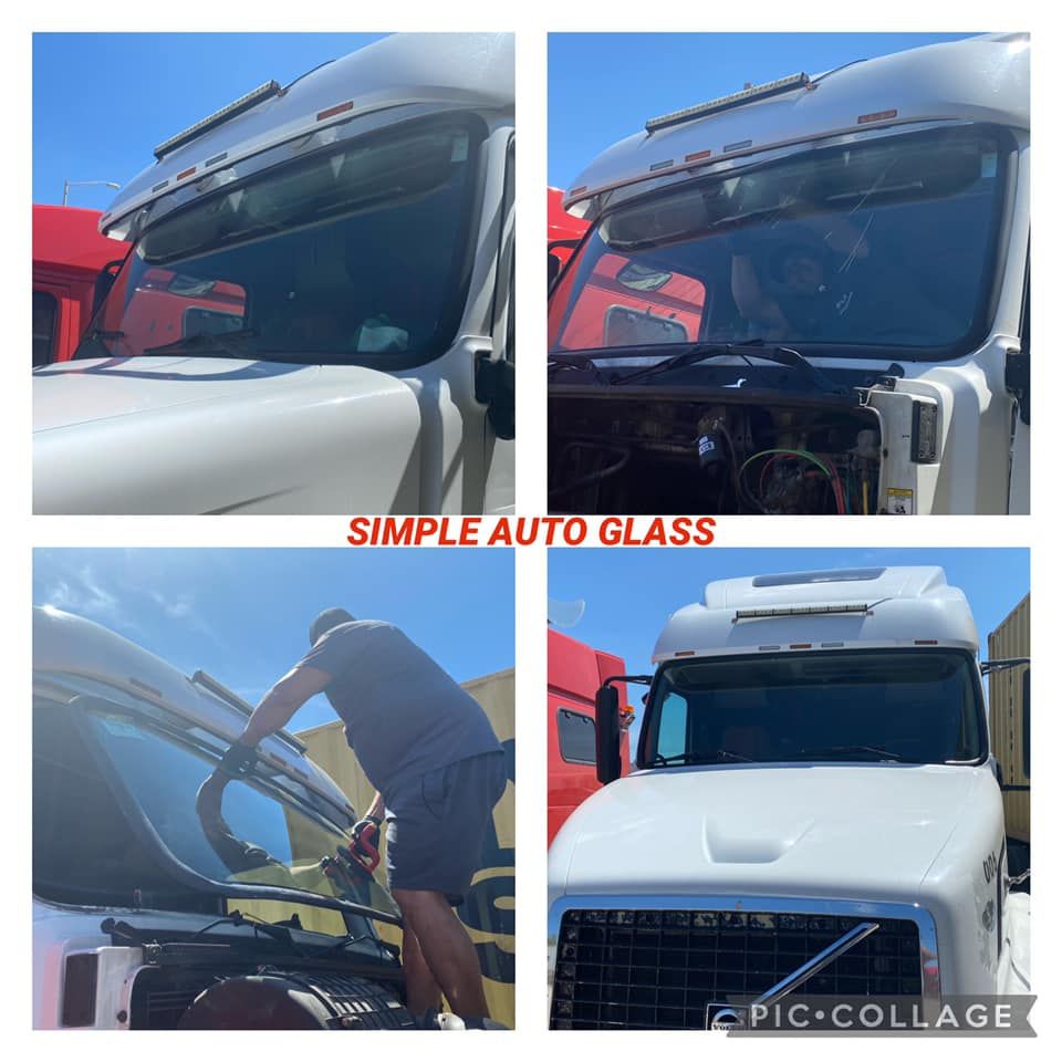 A man is installing a windshield on a white truck.