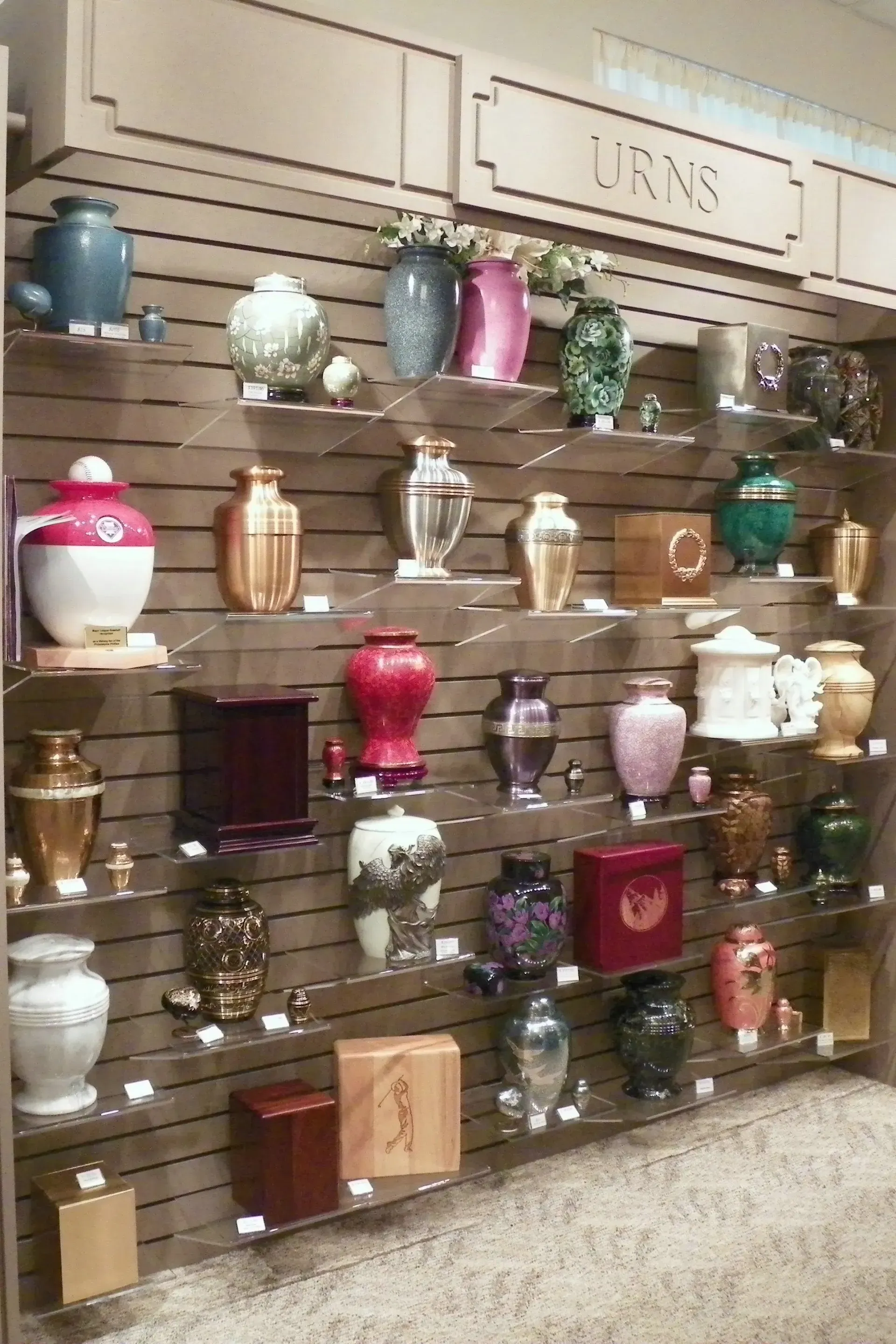 A wall of urns on shelves in a store