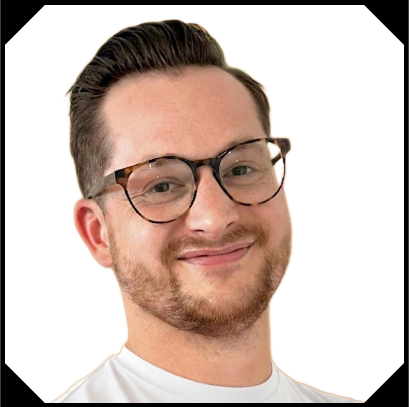 Man with glasses smiles, looking forward; wearing a white t-shirt.