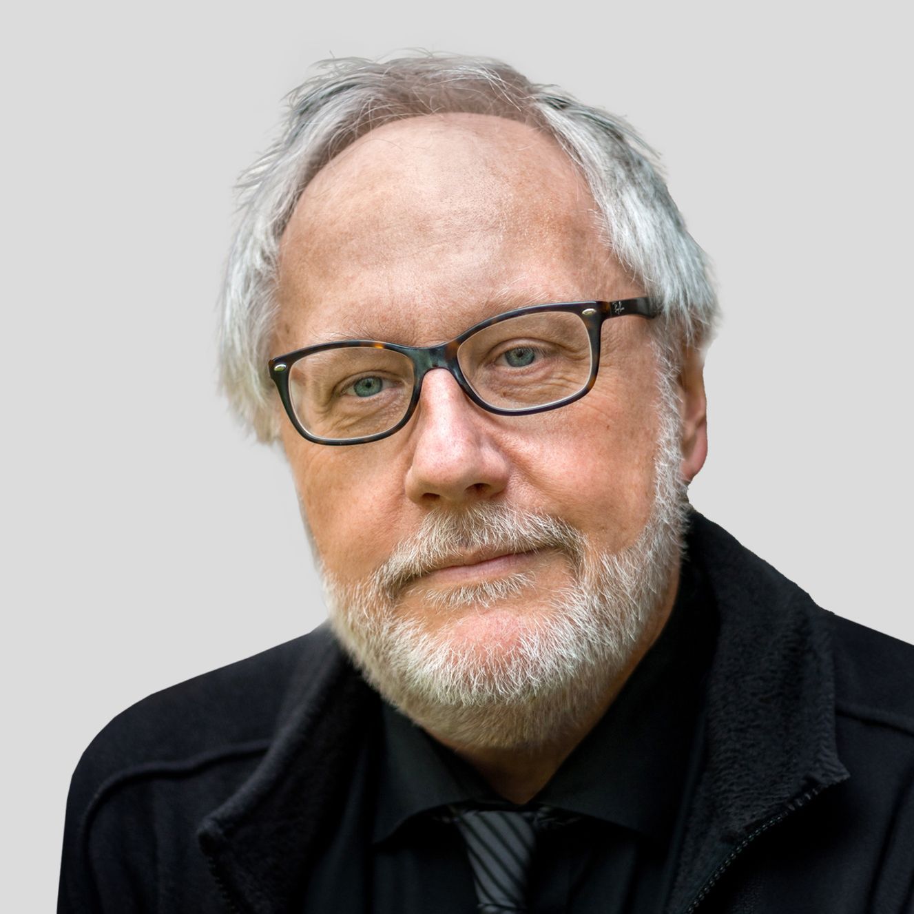 Porträtfoto von Richard Dünser, Juror, mit Brille, grauem Haar und Bart, vor neutralem Hintergrund.