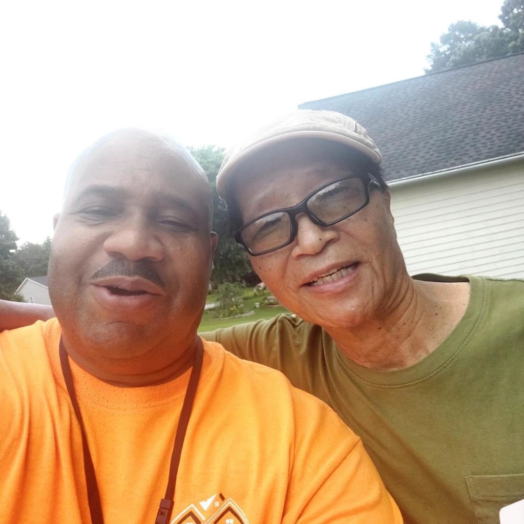 Two men posing for a picture with one wearing glasses