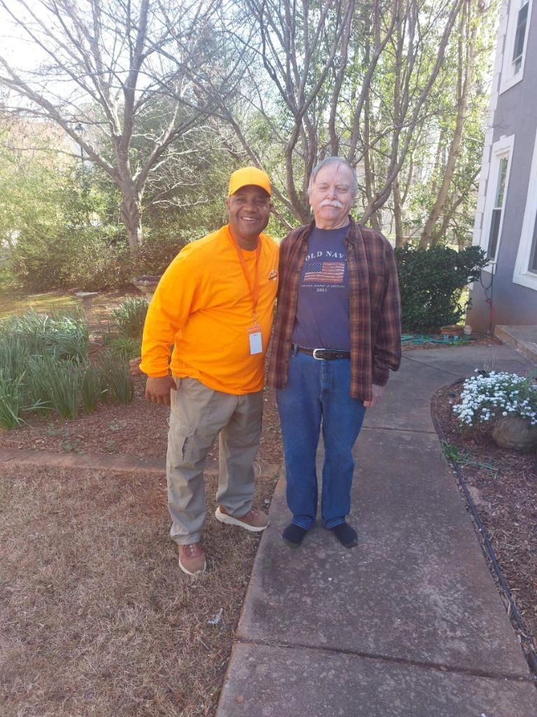 Two men are standing next to each other on a sidewalk.