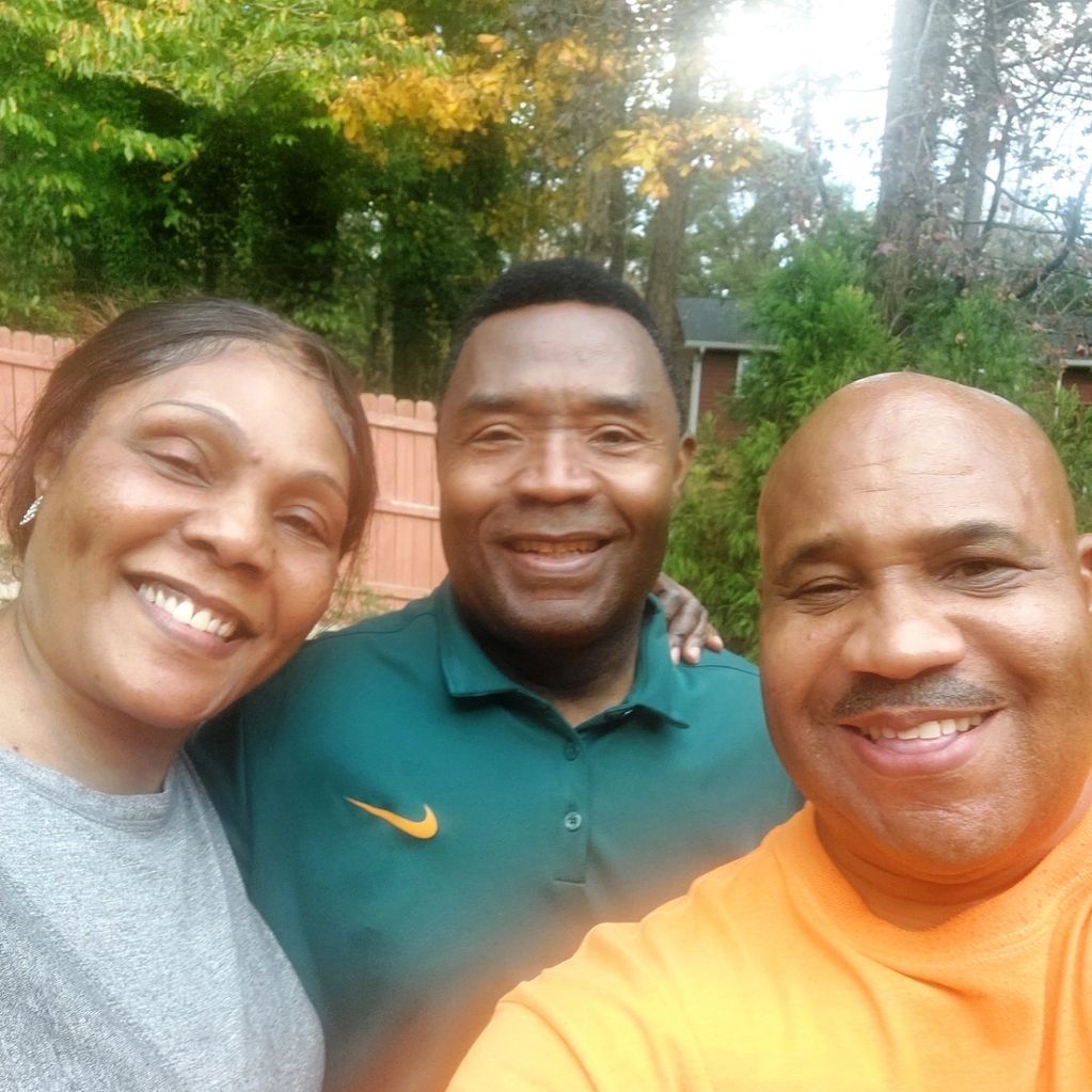 Two men and a woman are posing for a picture together