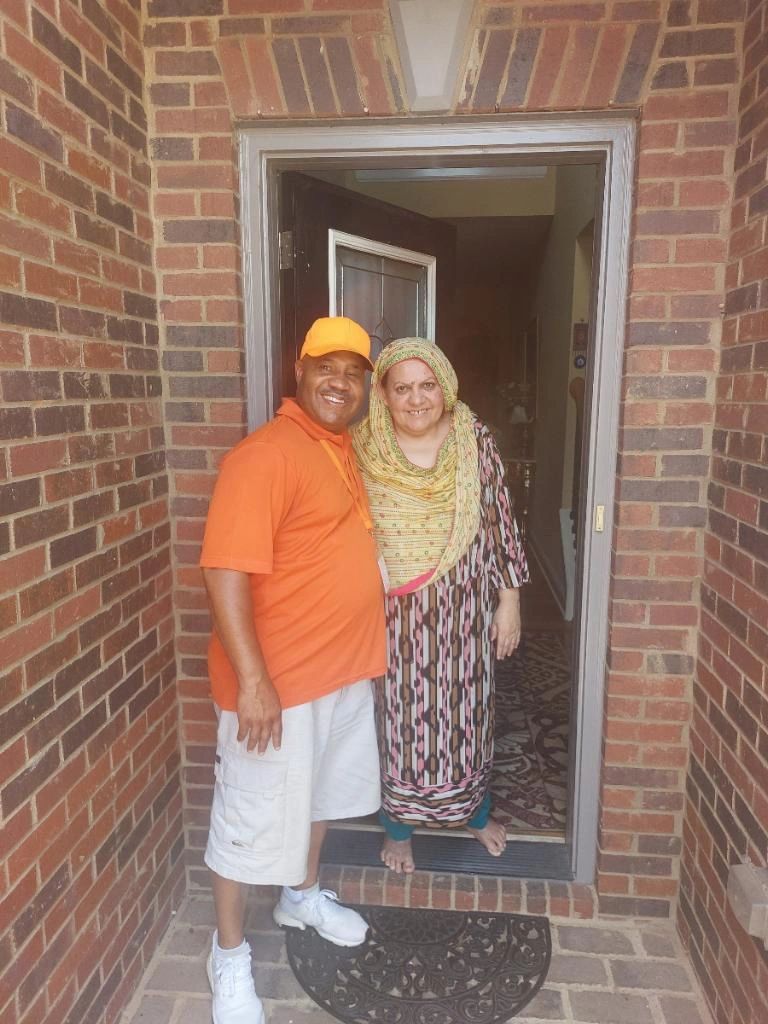 A man and a woman are standing in front of a brick door.
