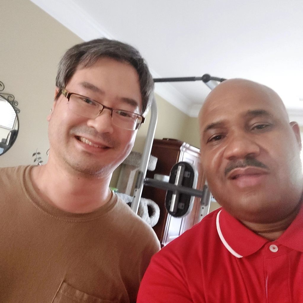 Two men are posing for a picture together in a living room