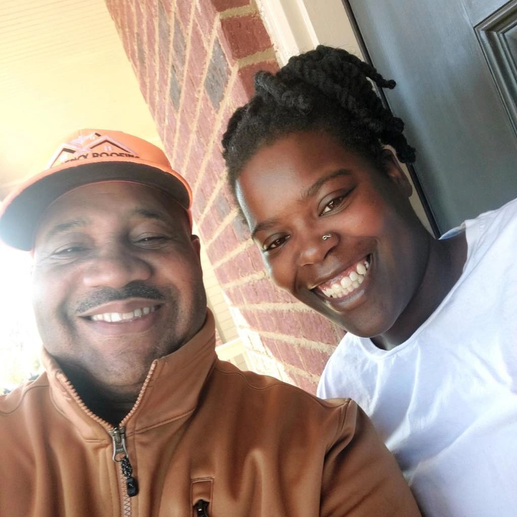 A man and a woman are posing for a picture together and smiling.