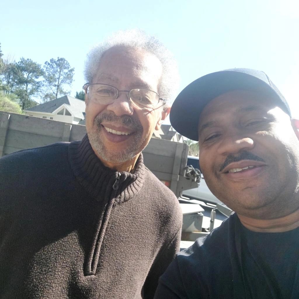 Two men are posing for a picture and smiling for the camera
