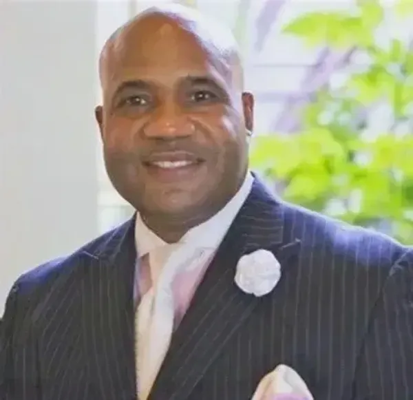 A man in a suit and tie is smiling for the camera.