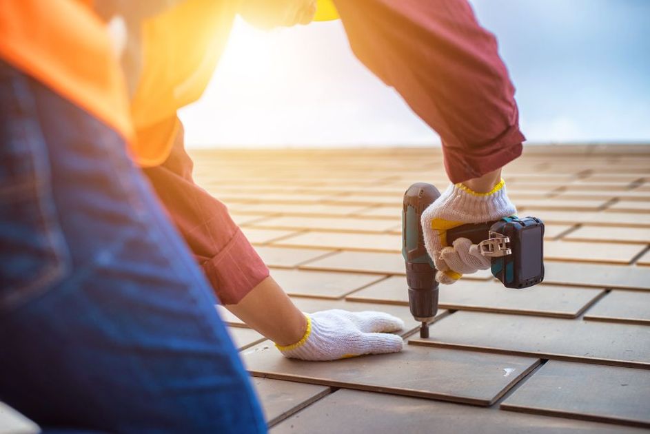 A man is using a drill to drill a hole in a brick wall.