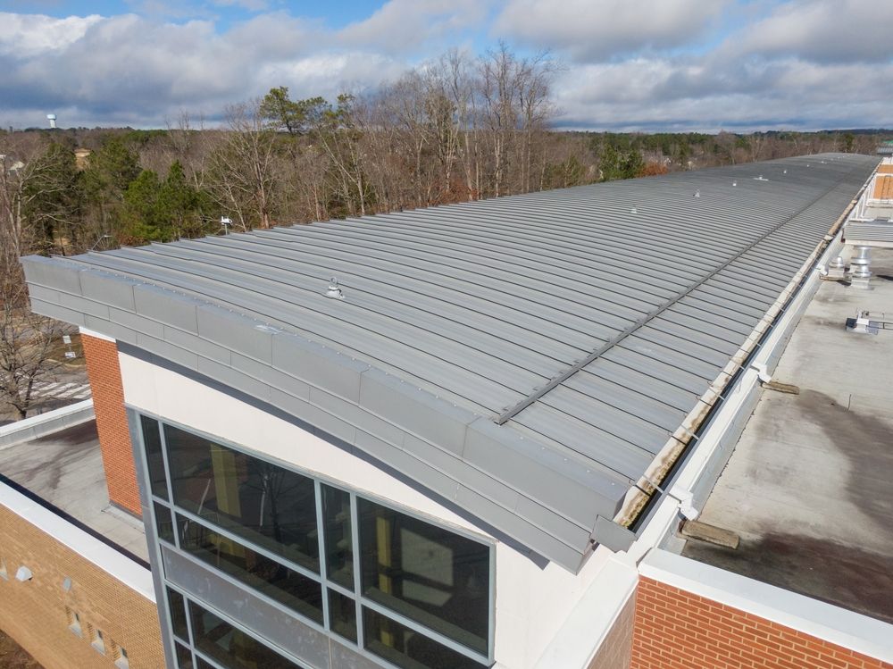 An aerial view of the roof of a building with trees in the background.