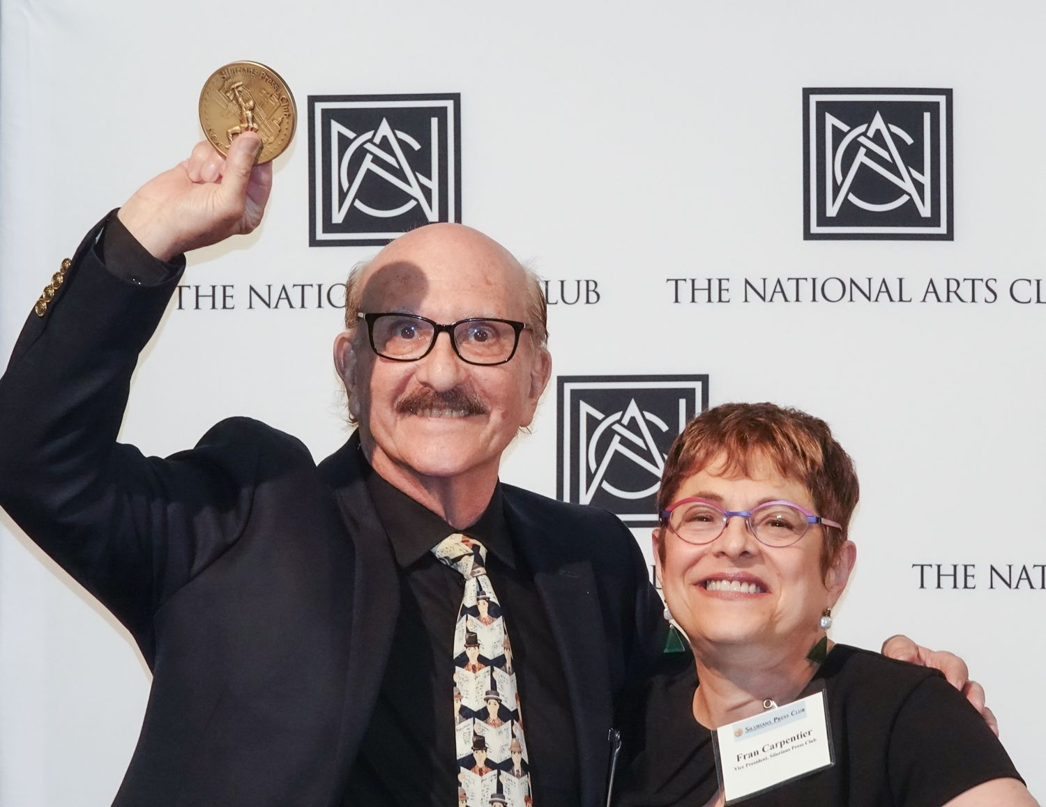 A man and woman are posing for a picture at the national arts club
