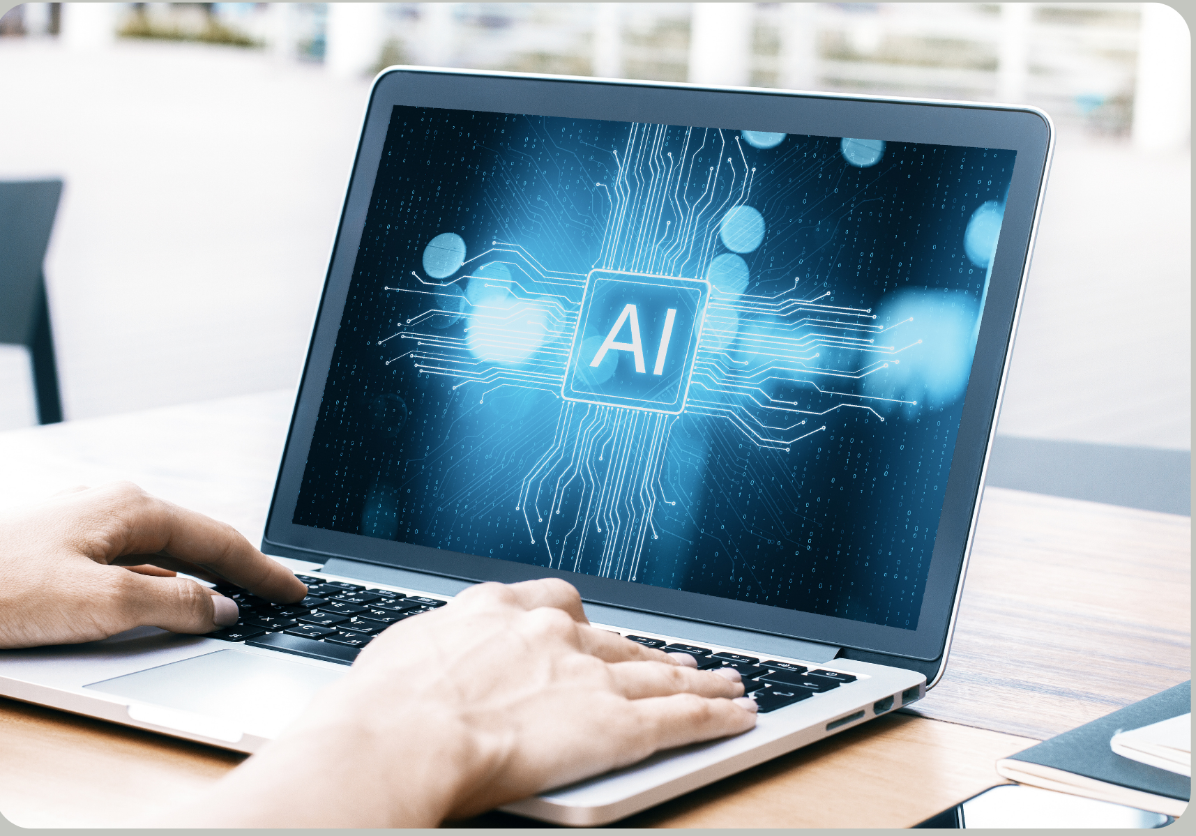 Person typing on laptop with AI graphic on the screen. Blue and white display with AI text and circuit-like lines.