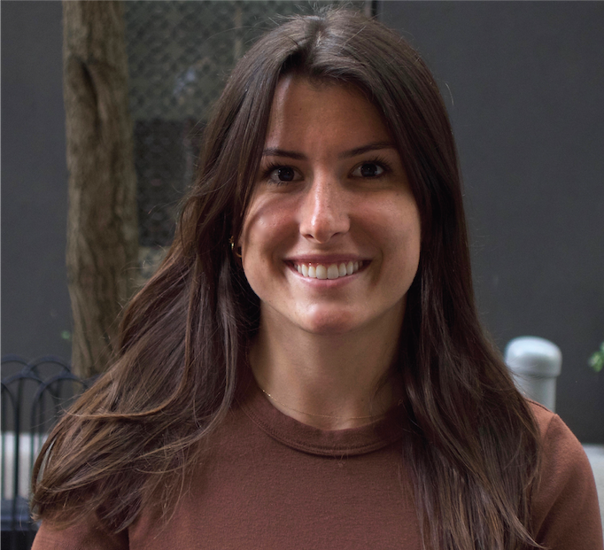 A woman with long brown hair is smiling for the camera