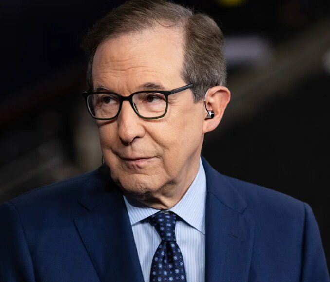 Chris Wallace in a blue suit and glasses, looking to the side.