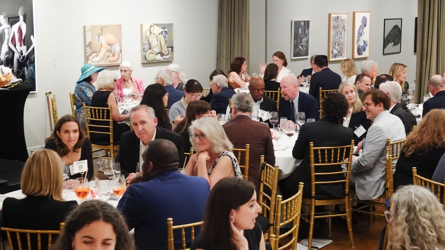 A large group of people are sitting at tables in a room.