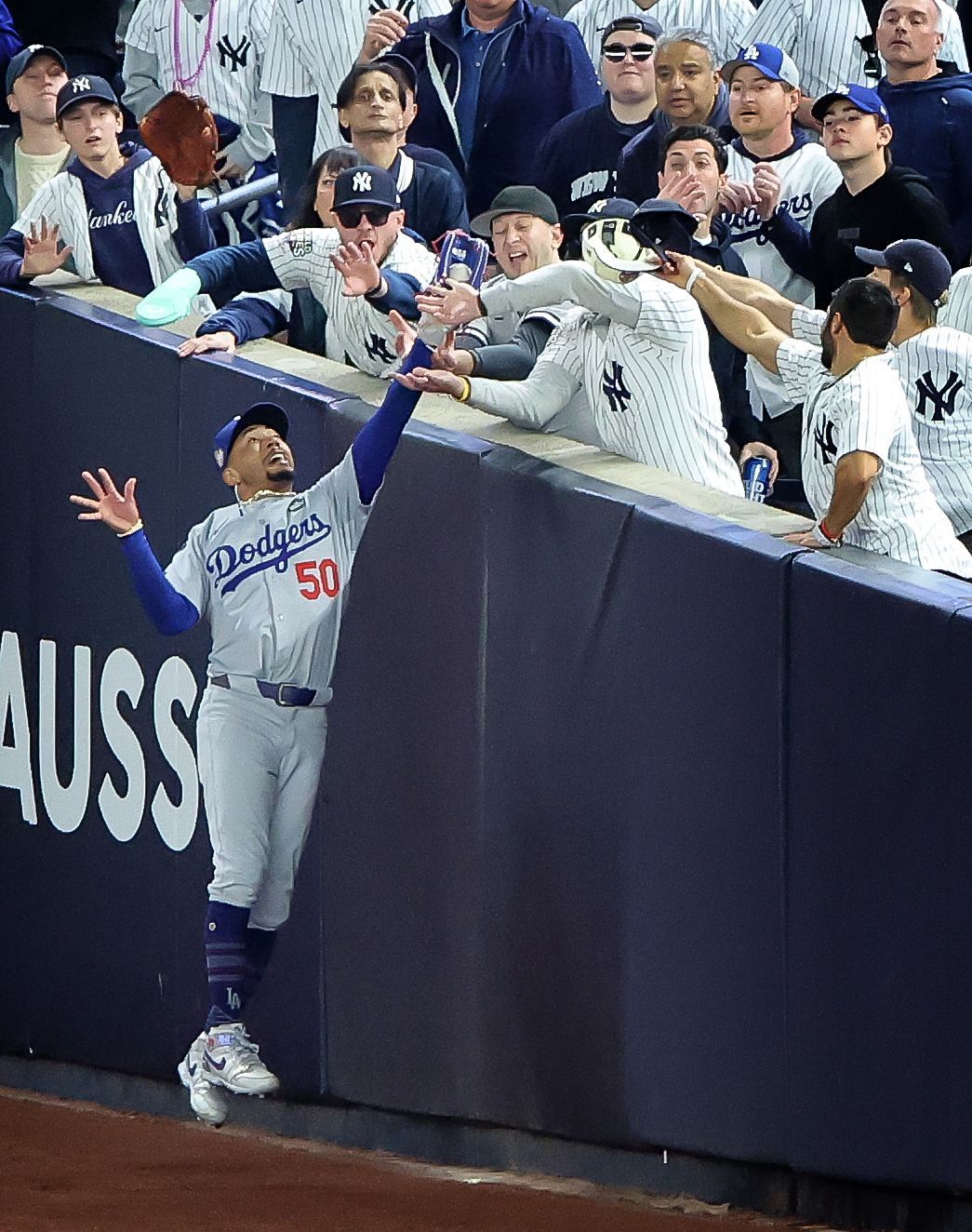 A dodgers baseball player reaches out to catch a ball