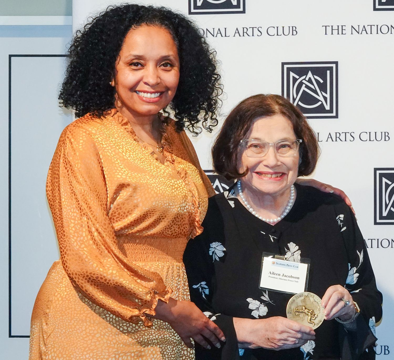 Two women standing in front of a sign that says national arts club