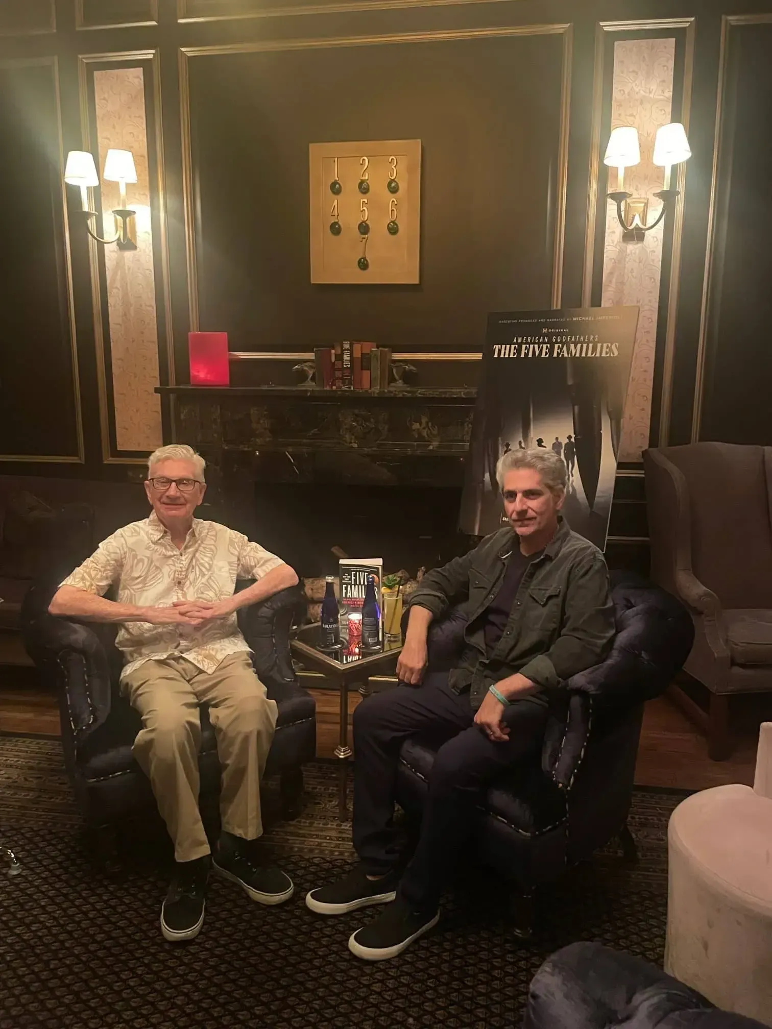 Two men are sitting in chairs in a living room.