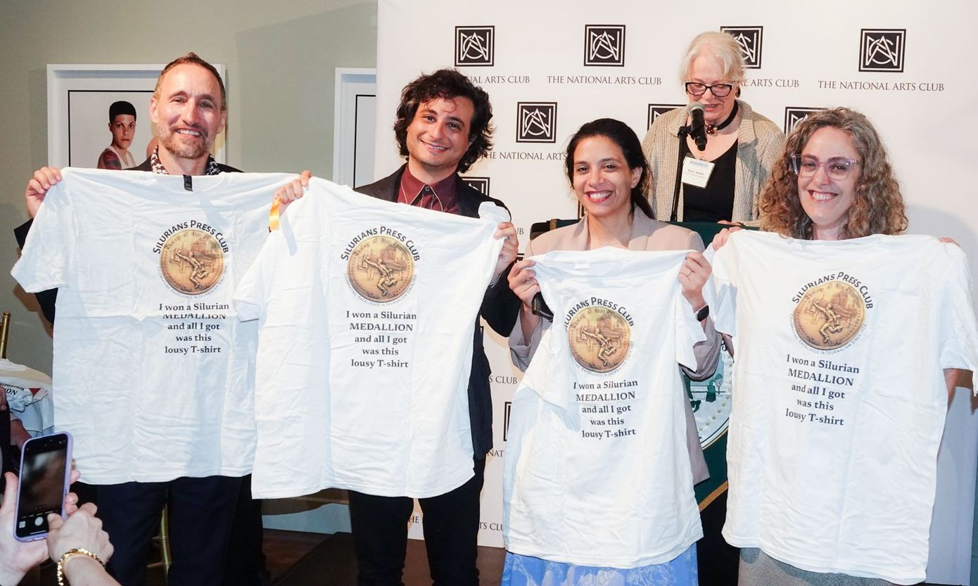 A group of people holding up t-shirts with a globe on them