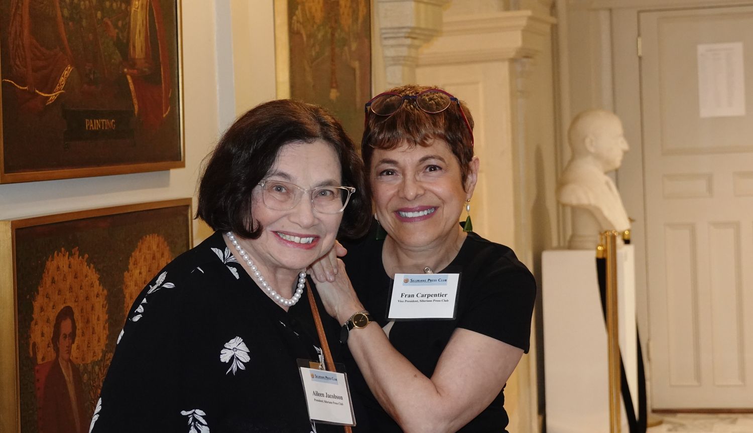 Two women are posing for a picture in a museum.