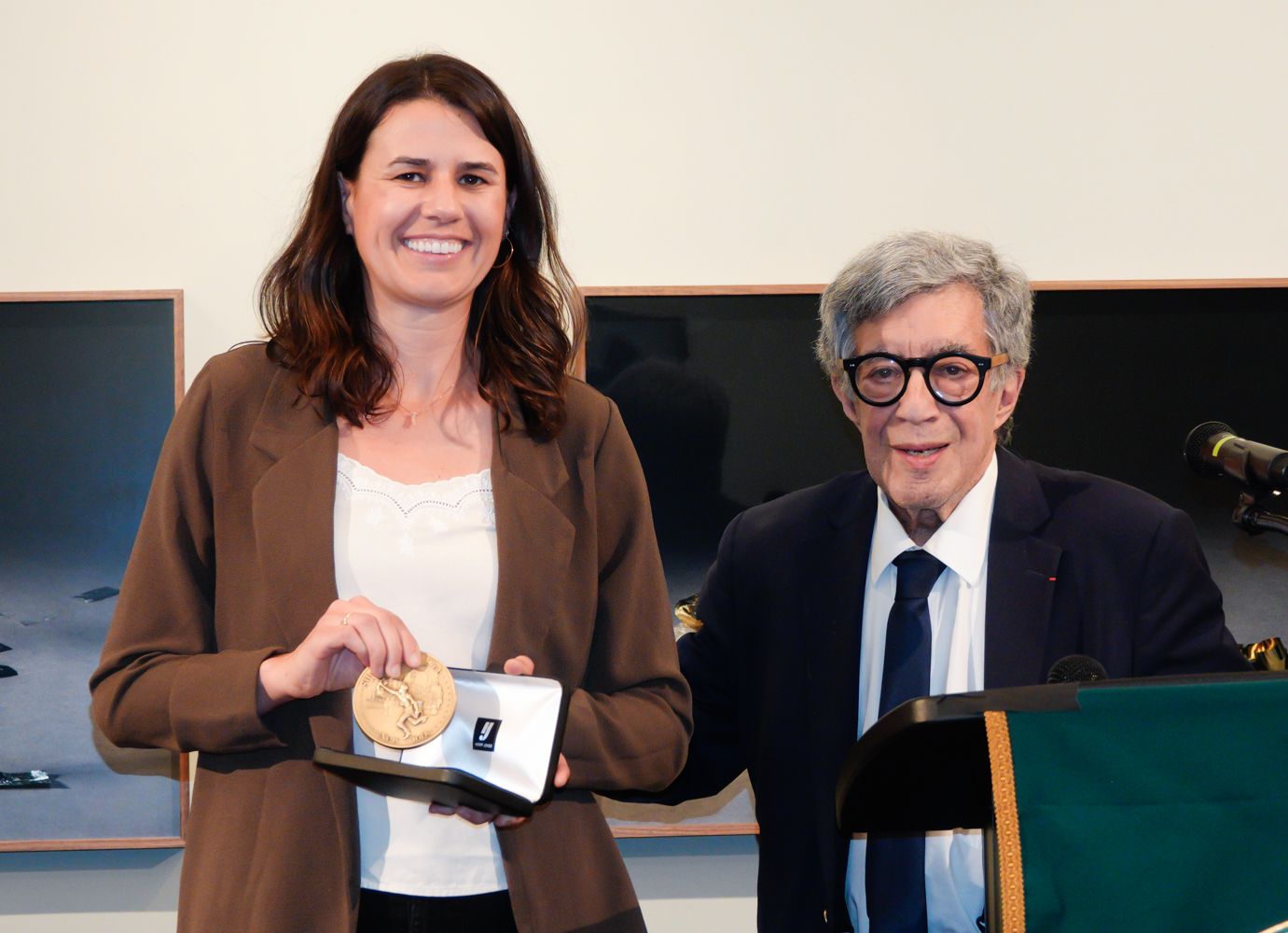 A man and a woman are standing next to each other in front of a podium.