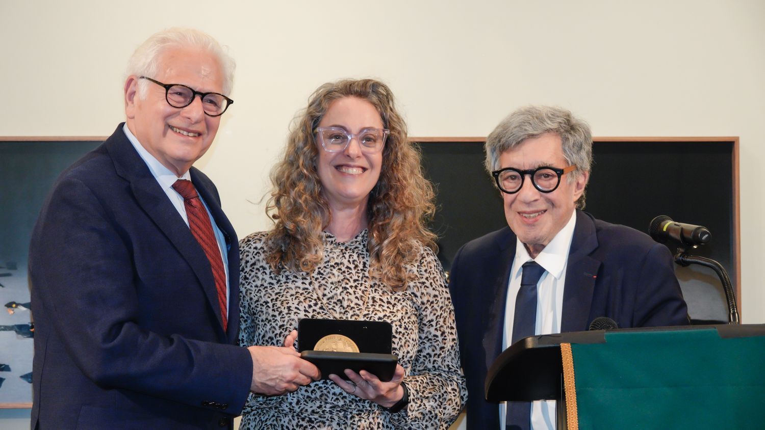 A man in a suit and tie is giving a woman a plaque.