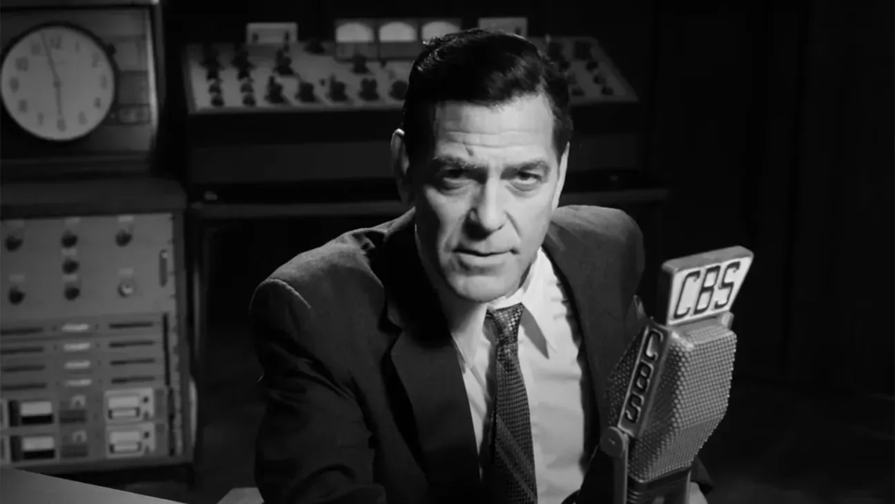 A man in a suit and tie is holding a microphone that says cbs on it.