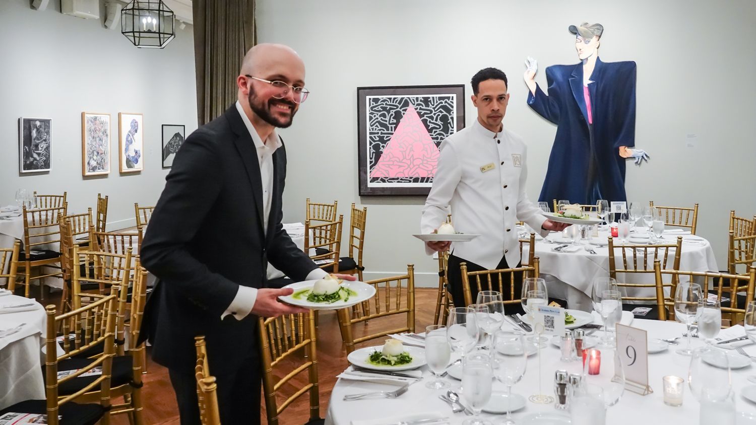 A man in a suit is holding a plate of food in a restaurant.