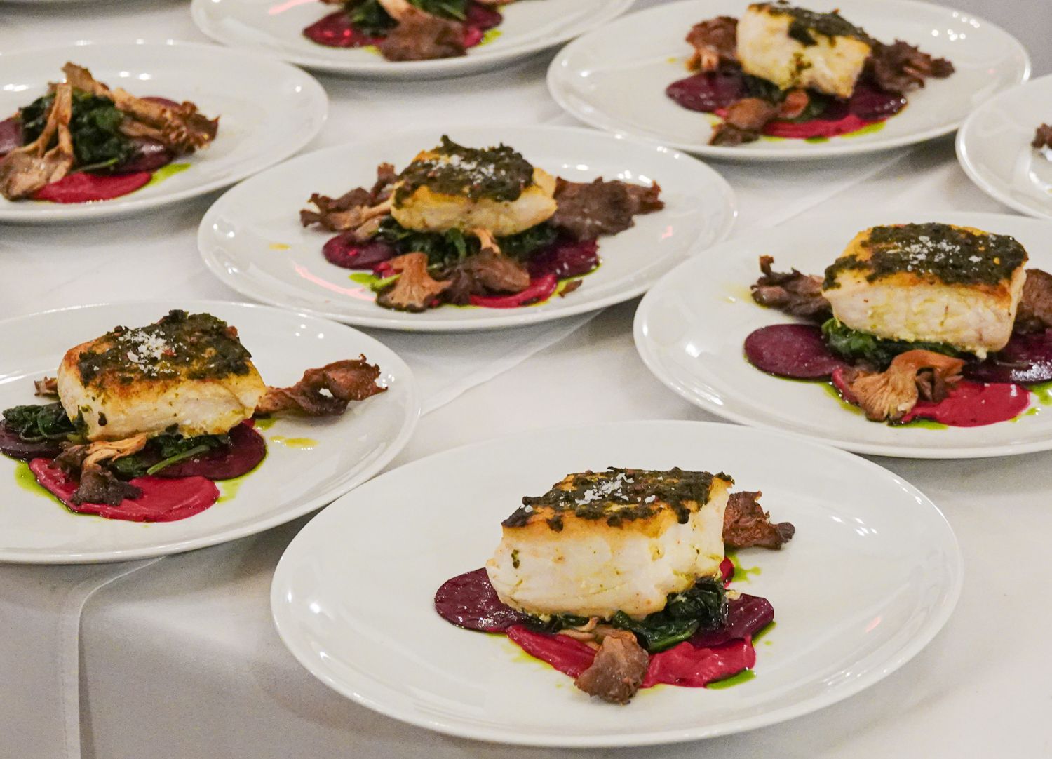 A table topped with plates of food with meat and vegetables on them.