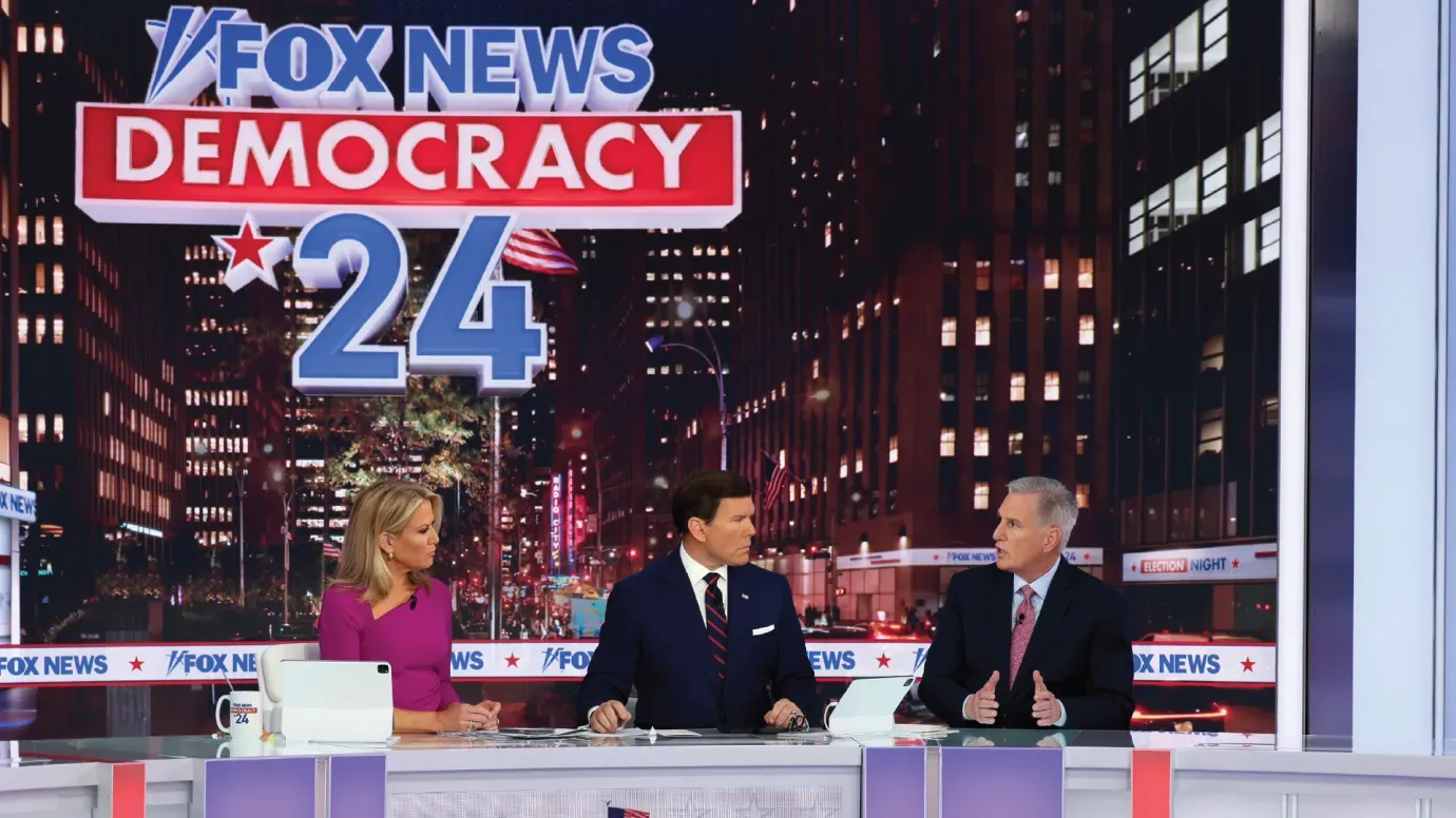 A group of people sitting in front of a sign that says fox news democracy 24