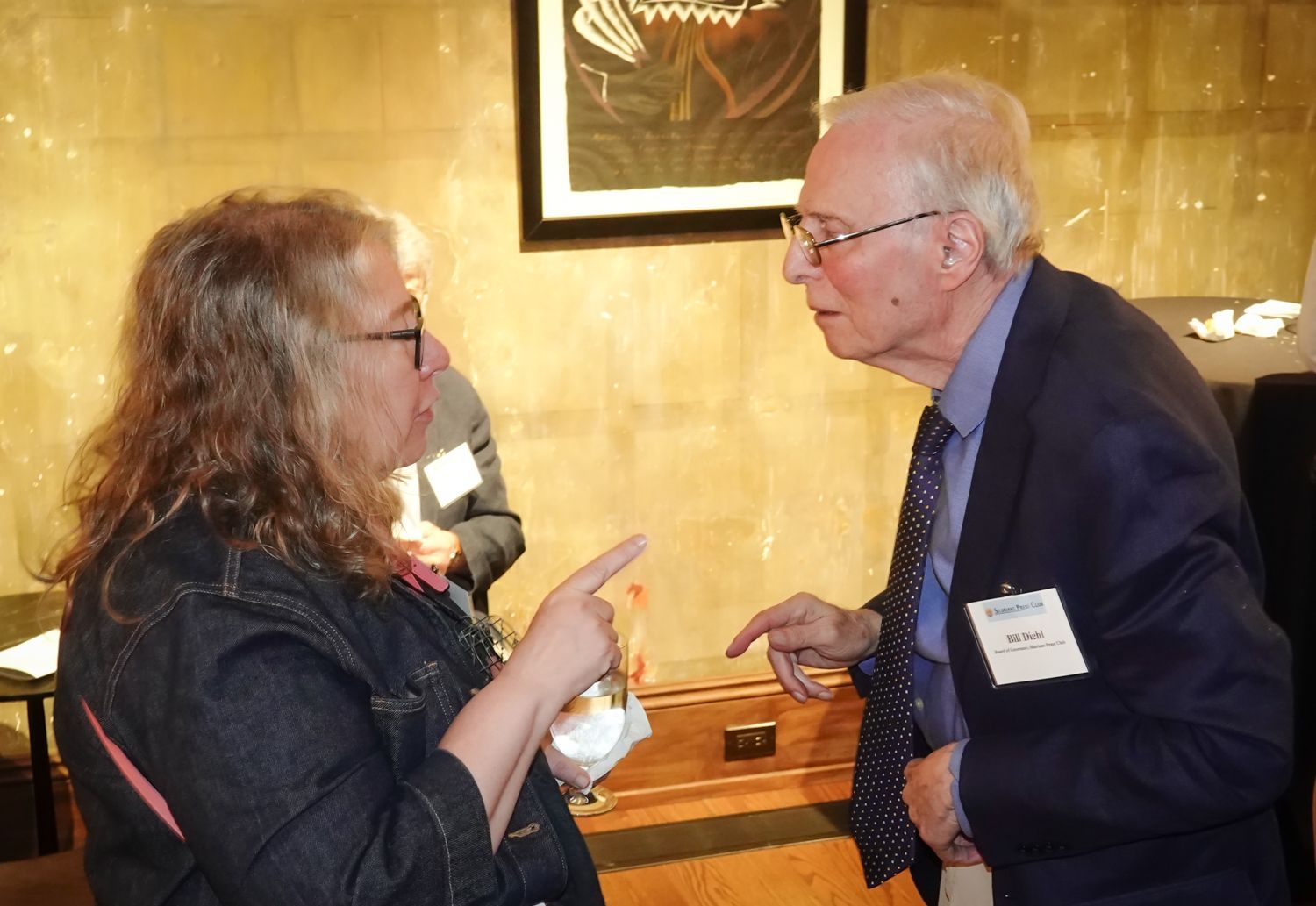 A man in a suit and tie is talking to a woman