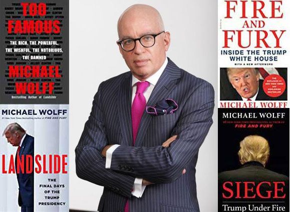 A man in a suit and tie is standing in front of three books by michael wolff