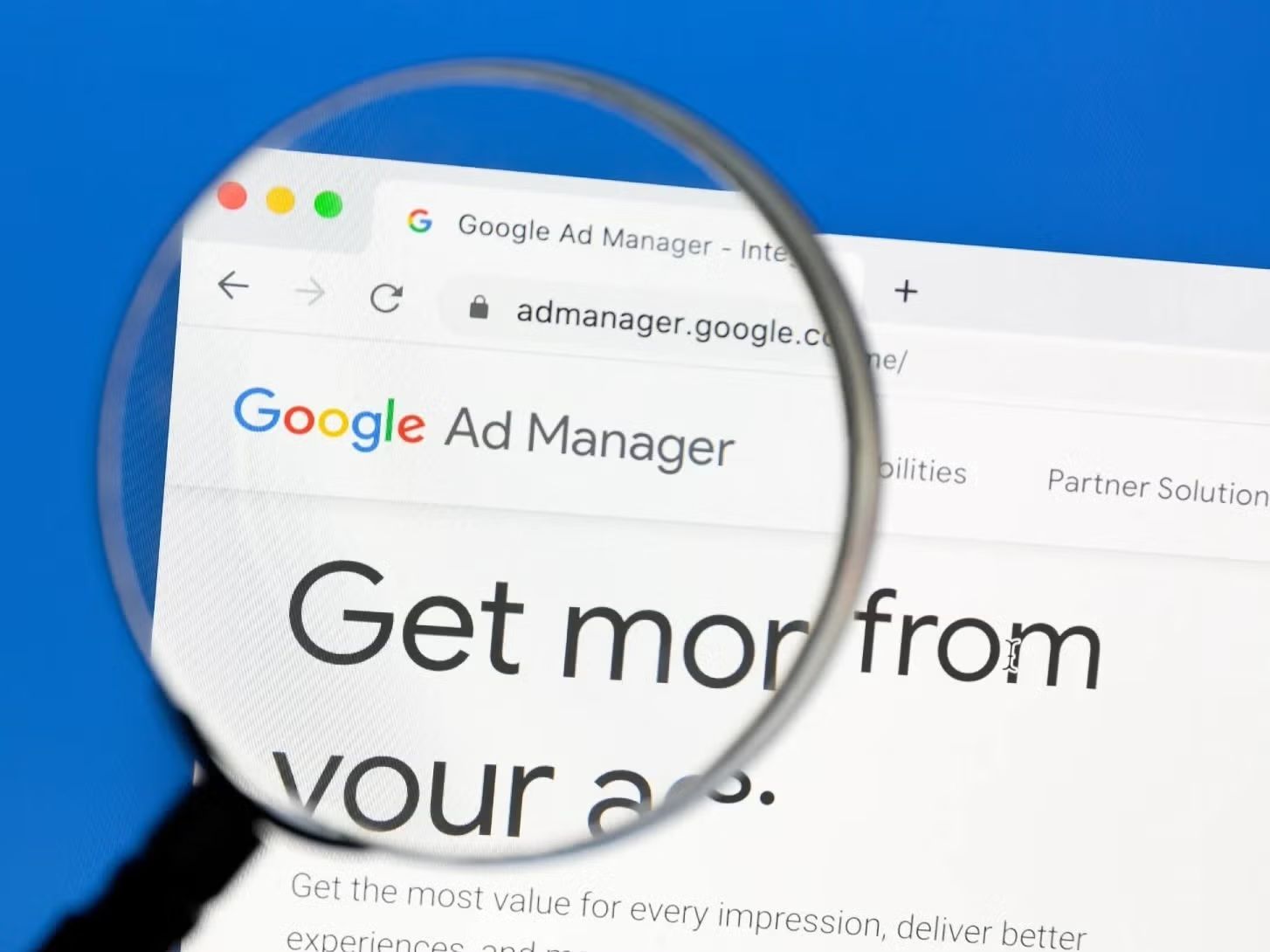Magnifying glass over a computer screen showing the Google Ad Manager login page.